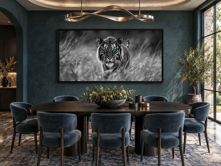Black and white tiger wall art with blue eyes in a black frame above a dining table.