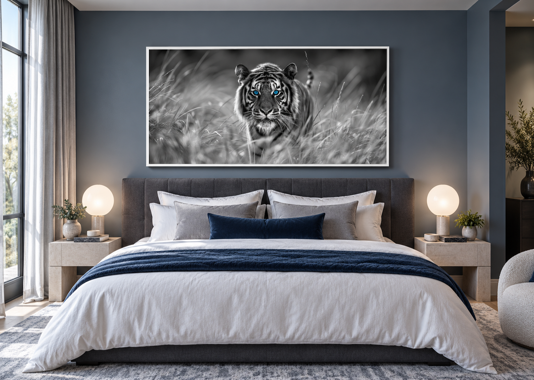 Black and white tiger wall art with blue eyes in a white frame above a bed in a modern bedroom.
