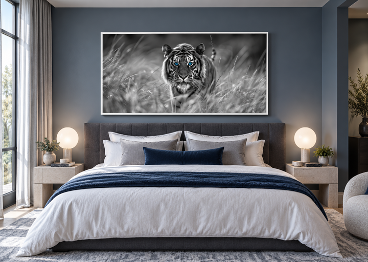 Black and white tiger wall art with blue eyes in a white frame above a bed in a modern bedroom.