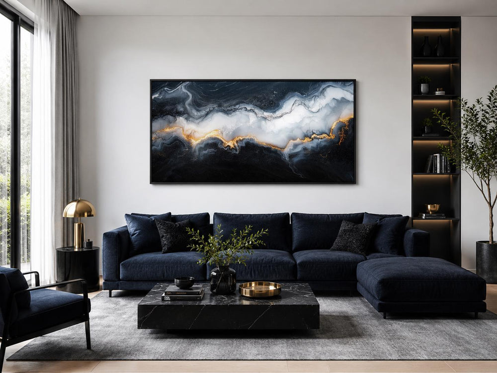 Large black, white, and gold abstract marble canvas print hanging above a navy sofa in a living room
