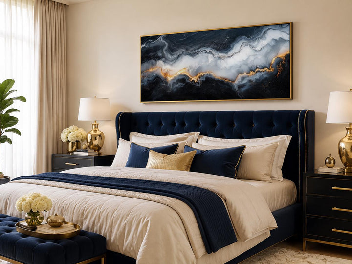 Large horizontal abstract marble canvas print with black, white, and gold veining above a bed.