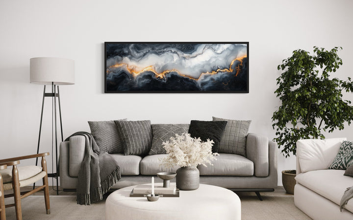 Black, white, and gold marble long horizontal framed canvas wall art above a gray sofa.