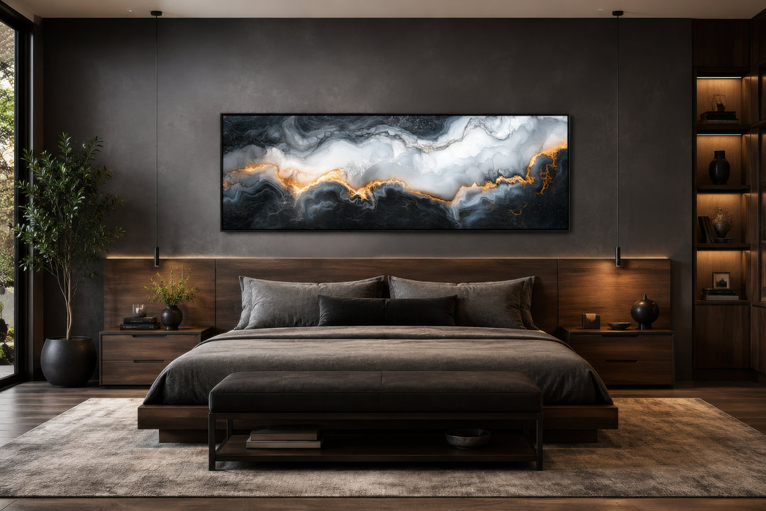 Horizontal framed canvas wall art with black, white, and gold marble pattern above a bed.