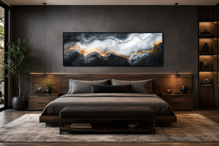 Horizontal framed canvas wall art with black, white, and gold marble pattern above a bed.