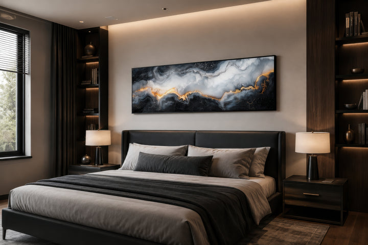 Black, white, and gold marble abstract painting in a long horizontal frame above a bed.