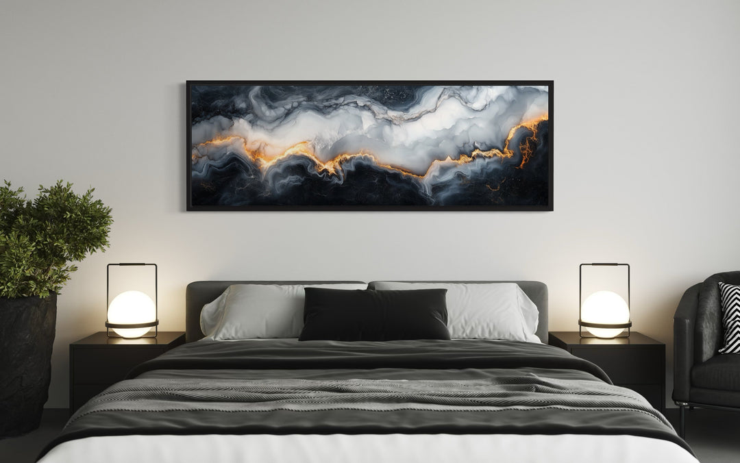 Black, white, and gold marble abstract framed canvas wall art hanging above a bed in a bedroom.