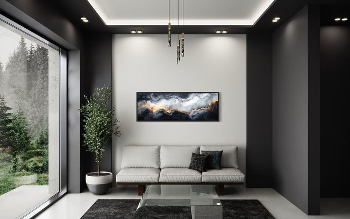Black, white, and gold marble horizontal framed canvas wall art hanging above a sofa in a room.
