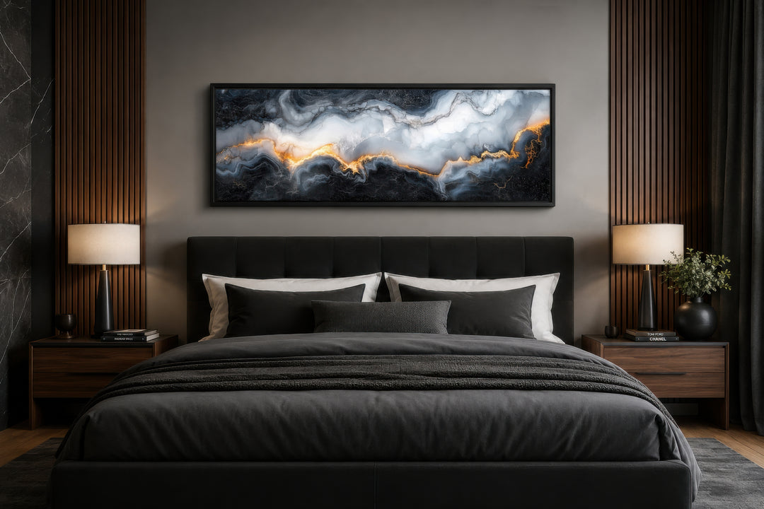 Long horizontal framed canvas wall art with black, white, and gold marble pattern above a bed.