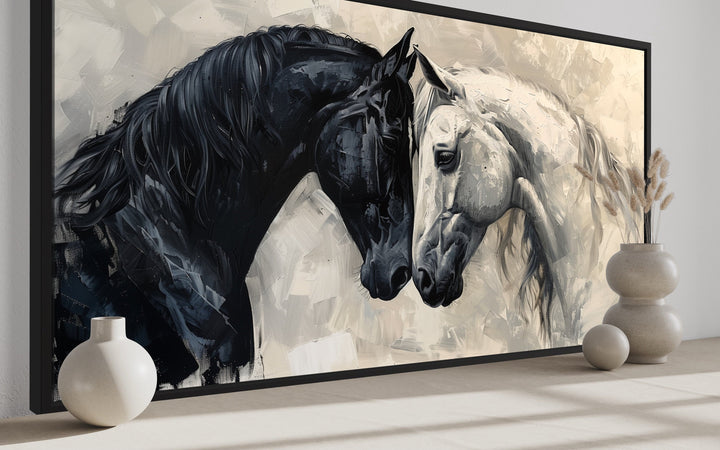Framed canvas wall art of a black horse and a white horse touching foreheads in an abstract style.
