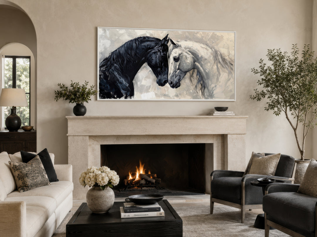 Framed canvas wall art of a black and white horse touching heads above a stone fireplace.
