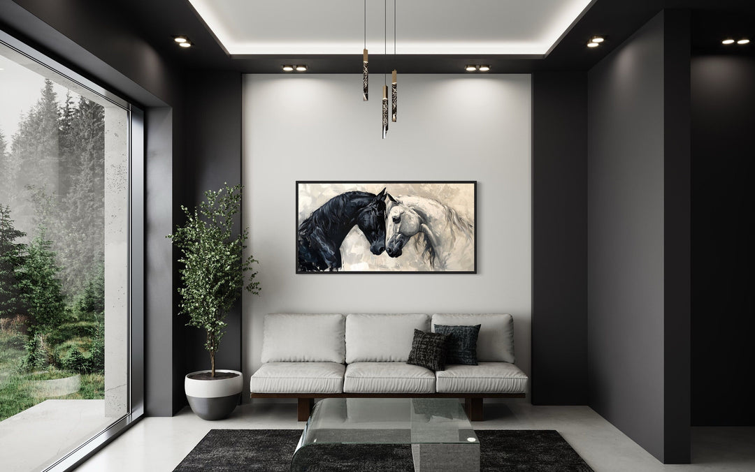 Framed canvas wall art of a black and white horse embracing, hung above a sofa in a modern room.