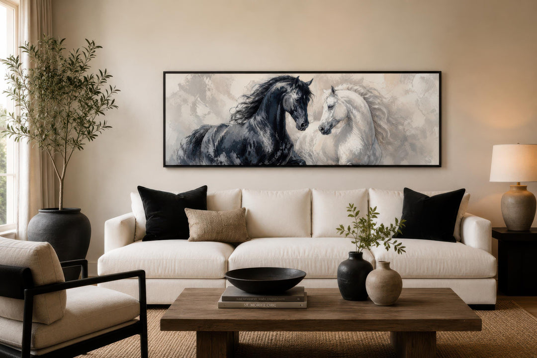 Long horizontal canvas print of a black and white horse together above a white sofa.