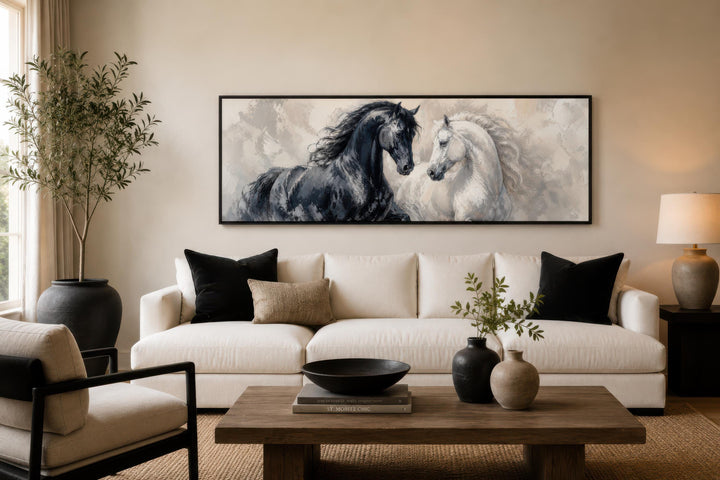 Long horizontal canvas print of a black and white horse together above a white sofa.