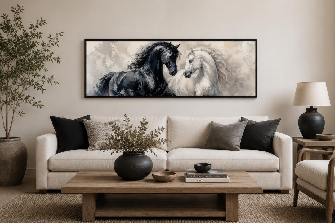 Long horizontal canvas print of a black and white horse in a modern living room above a sofa.