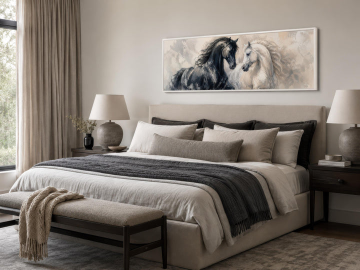 Long horizontal canvas print of a black and white horse duo above a neutral-toned bed.