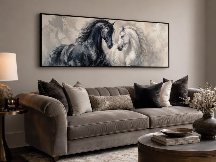 Black and white horse canvas print in a long horizontal frame above a velvet sofa.