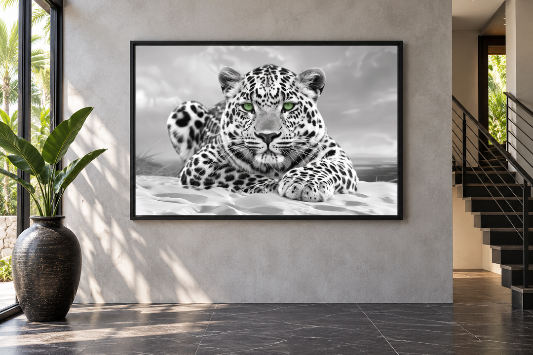 Black and white leopard photography framed canvas with piercing green eyes on a modern gray wall.