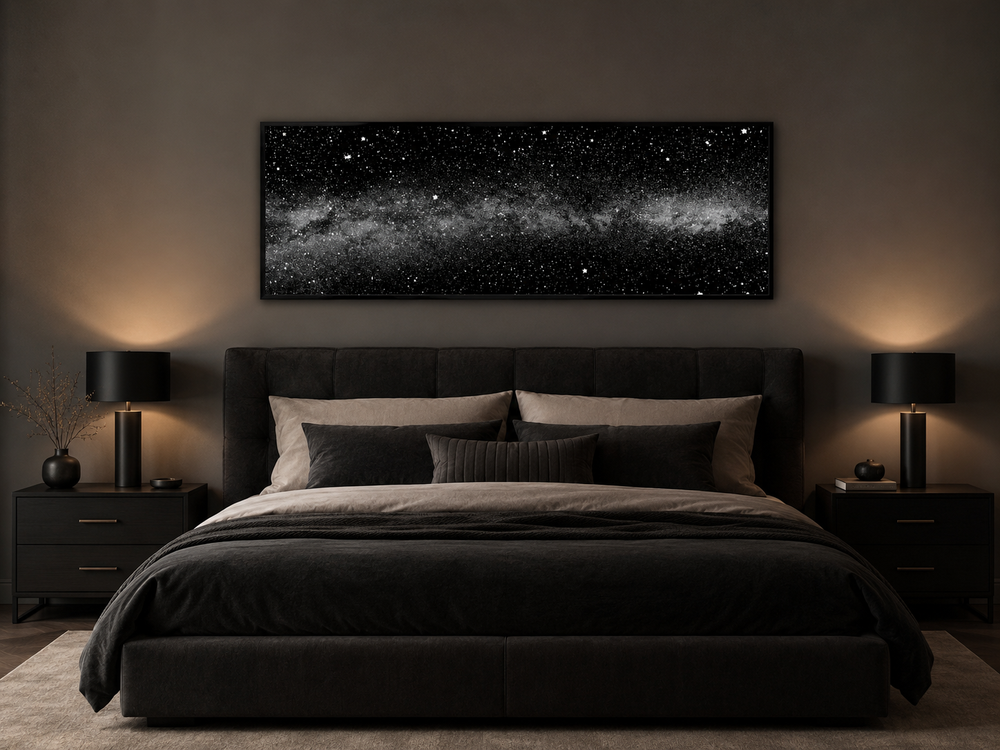 Framed black and white night sky canvas art above a dark bed in a modern bedroom.
