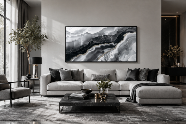 Large horizontal black and white abstract marble canvas art above a modern sofa in a living room.
