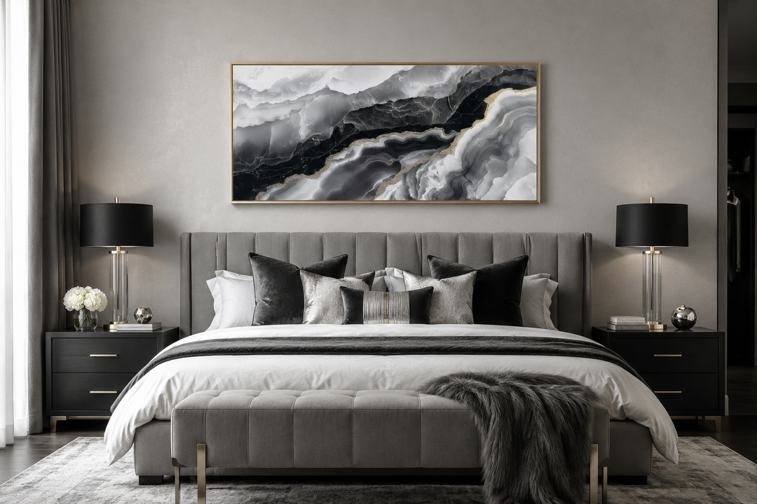 Horizontal abstract marble canvas wall art with black, white, and gold veins above a grey bed.
