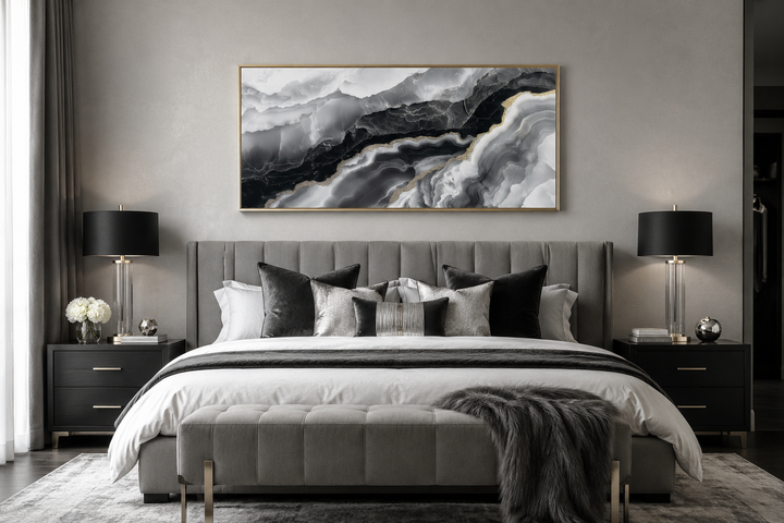 Horizontal abstract marble canvas wall art with black, white, and gold veins above a grey bed.
