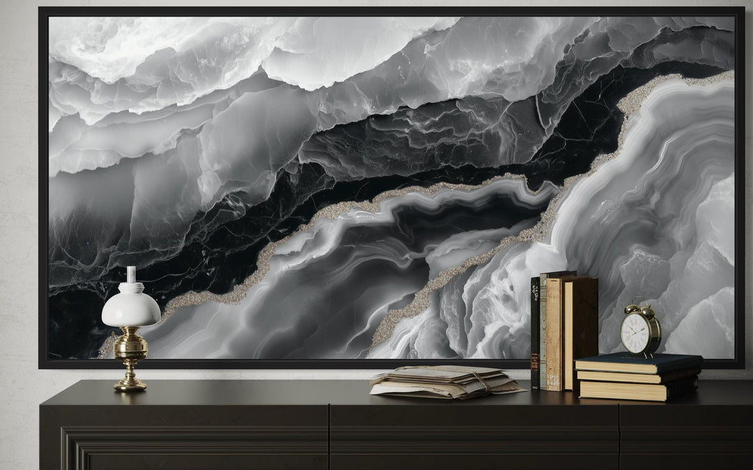 Framed black and white abstract marble canvas wall art above a dark wood console table.
