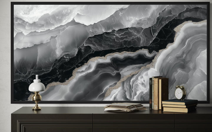 Framed black and white abstract marble canvas wall art above a dark wood console table.