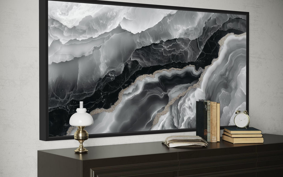 Black and white abstract marble canvas wall art in a black frame above a dark wood dresser.