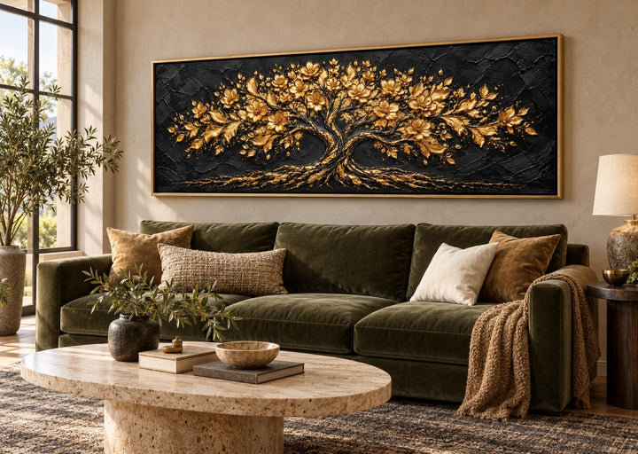 Black and gold flowering tree horizontal canvas wall art above a green velvet sofa in a living room.
