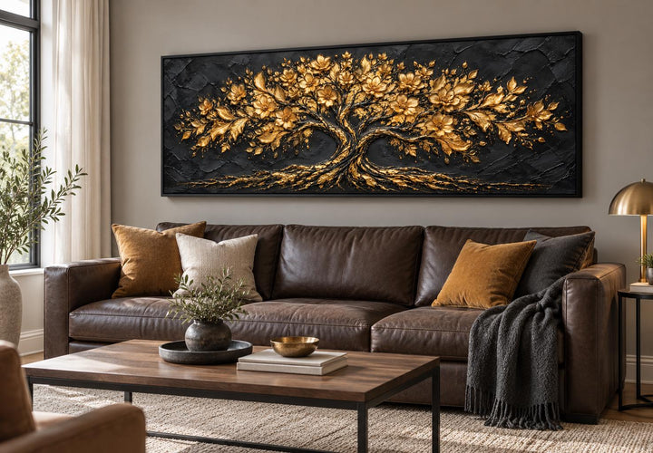 Black and gold flowering tree long horizontal canvas wall art above a brown leather sofa.