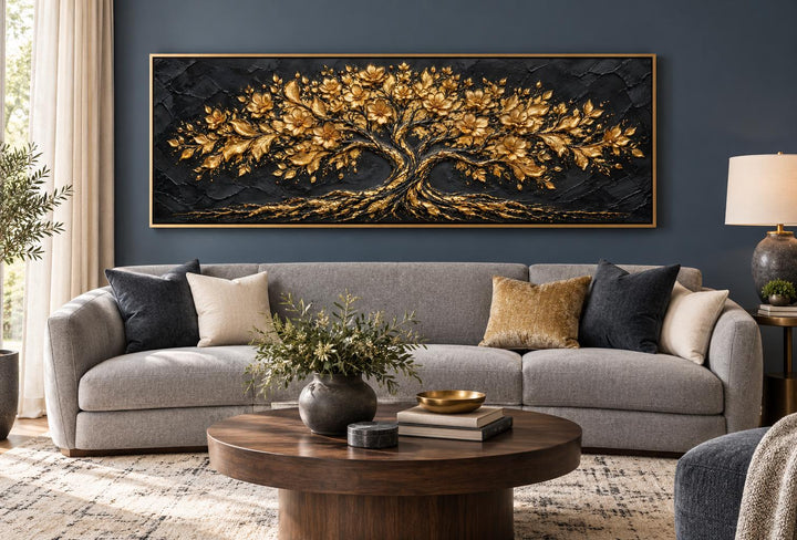 Black and gold flowering tree canvas wall art above a gray sofa in a modern living room.