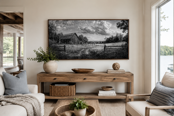 Black and white barn landscape canvas wall art above a wooden console table in a farmhouse room.