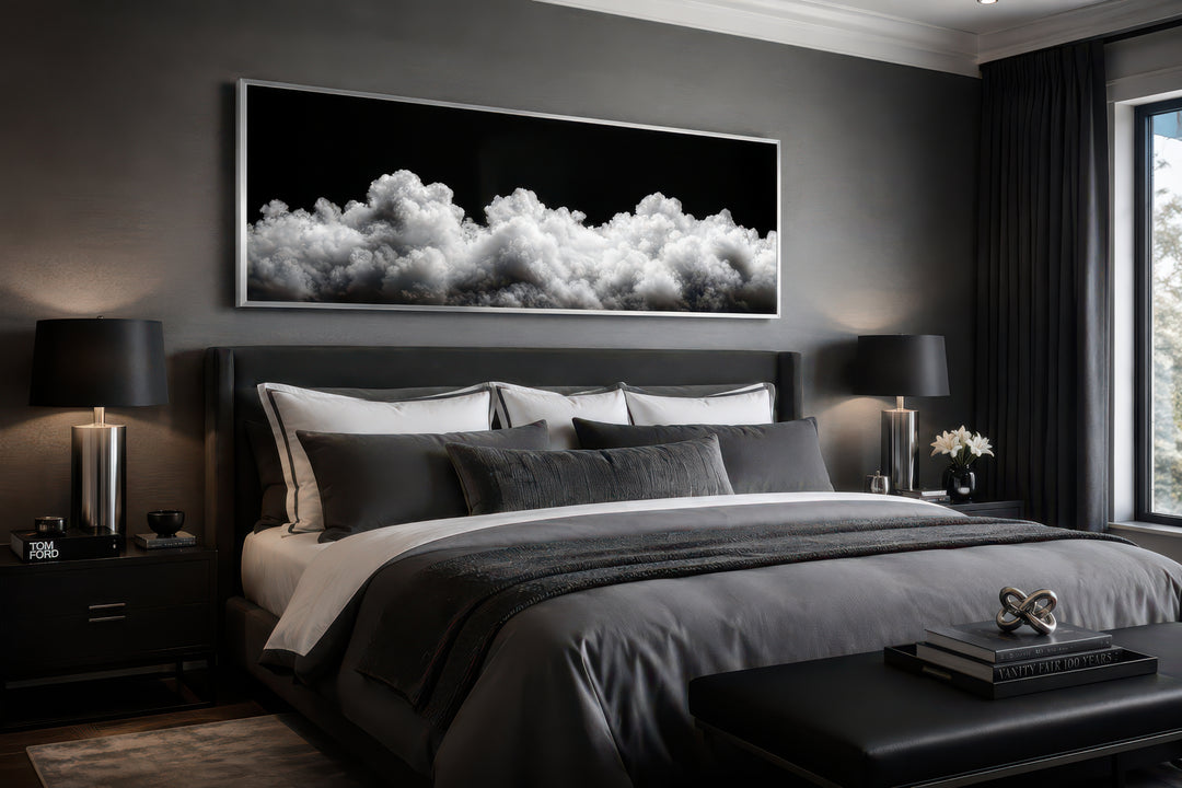Black and white clouds long horizontal framed canvas wall art hanging above a bed in a bedroom.