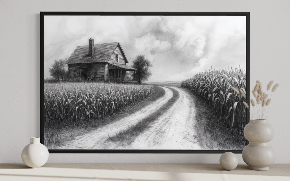 Black and white farmhouse wall art featuring a rustic cornfield landscape in a black frame.