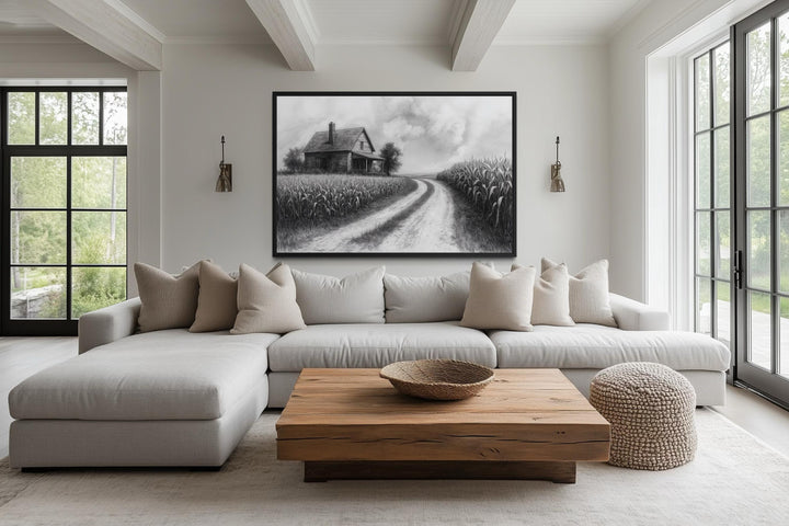 Black and white farmhouse wall art featuring a cornfield landscape above a modern sectional sofa.