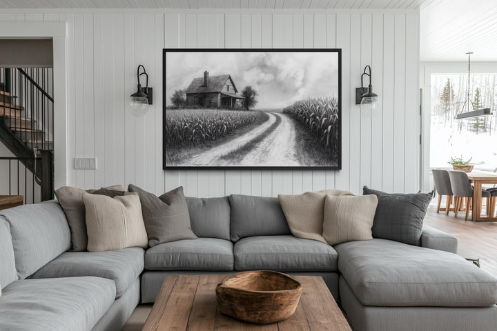 Black and white farmhouse wall art featuring a cornfield landscape above a grey sectional sofa.
