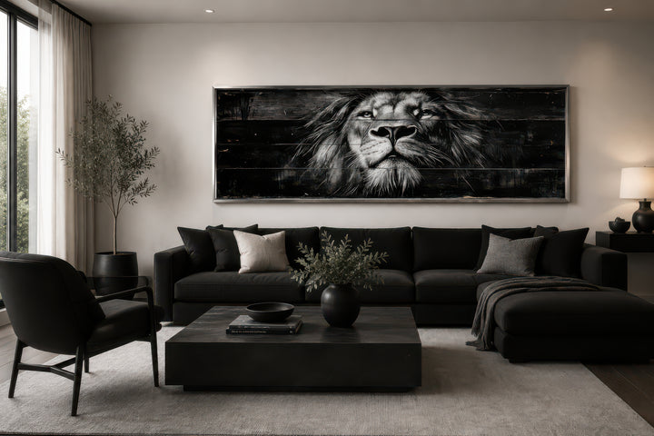 Black and white horizontal canvas wall art of a lion's face above a black sofa in a modern room.