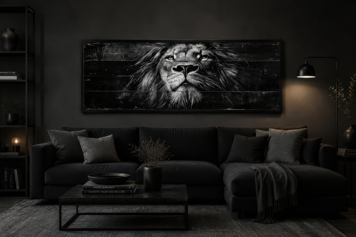 Black and white lion horizontal canvas wall art above a black sofa in a dark, modern living room.