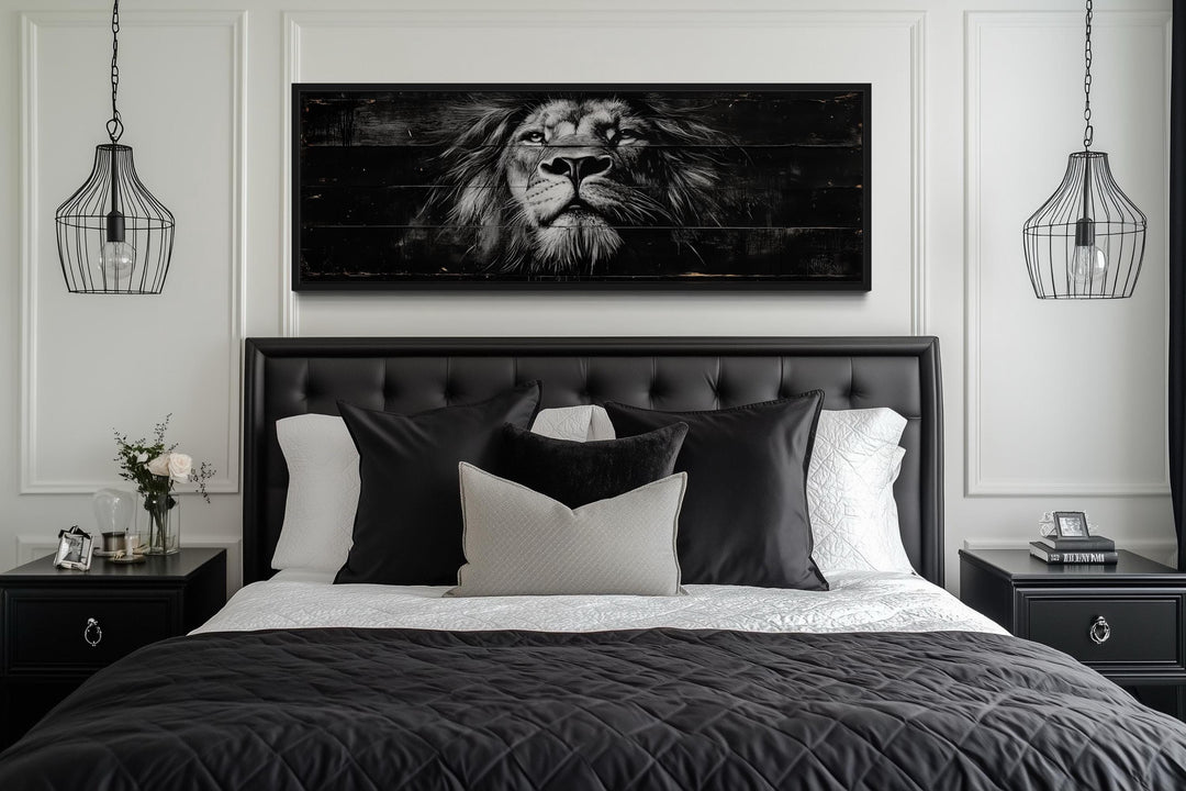 Black and white lion horizontal canvas wall art centered above a black tufted headboard in a bedroom.
