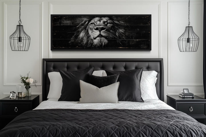 Black and white lion horizontal canvas wall art centered above a black tufted headboard in a bedroom.
