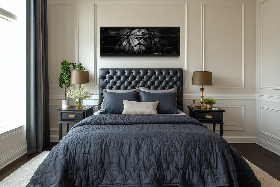 Black and white lion horizontal canvas wall art centered above a tufted black leather headboard.