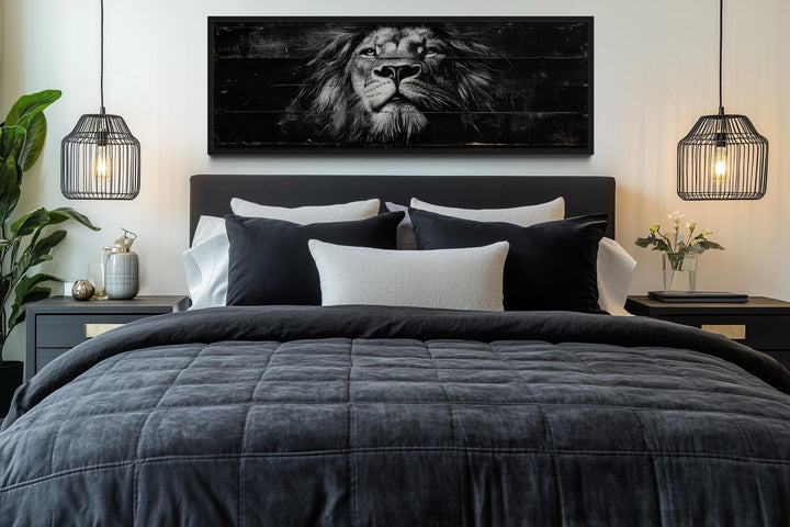 Black and white lion horizontal canvas wall art centered above a bed with dark gray bedding.