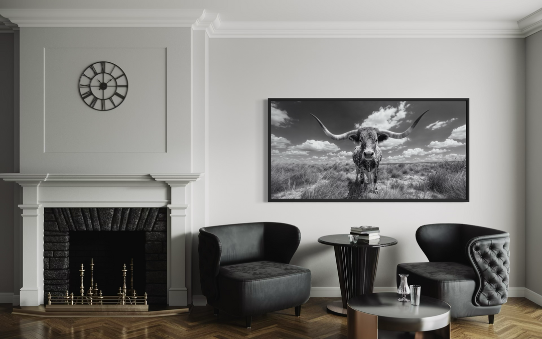 Black and white longhorn photography framed canvas wall art in a modern living room setting.