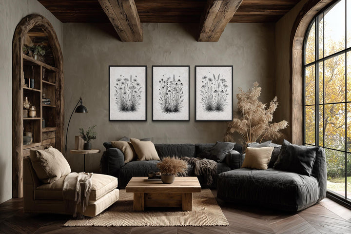 Set of three black and white wildflower canvas prints displayed in a rustic farmhouse living room.