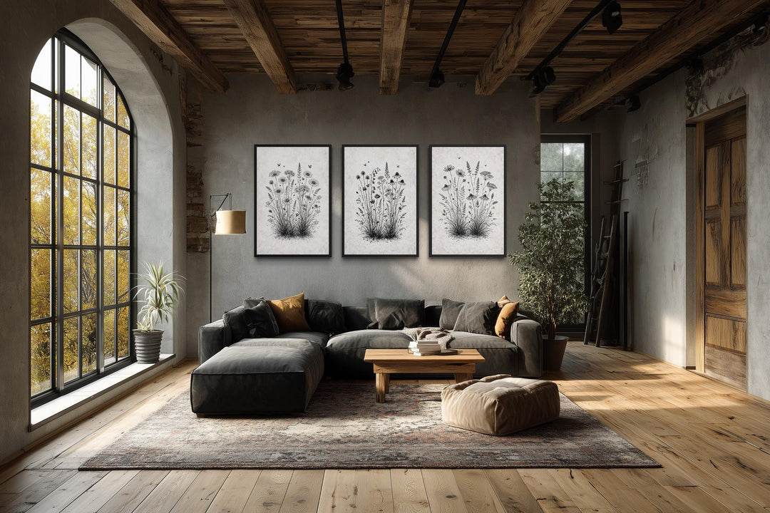 Set of three black and white wildflower canvas prints in a rustic farmhouse living room.