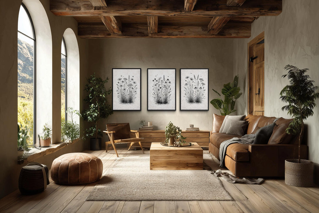Set of three black and white wildflower canvas prints in a rustic farmhouse living room.