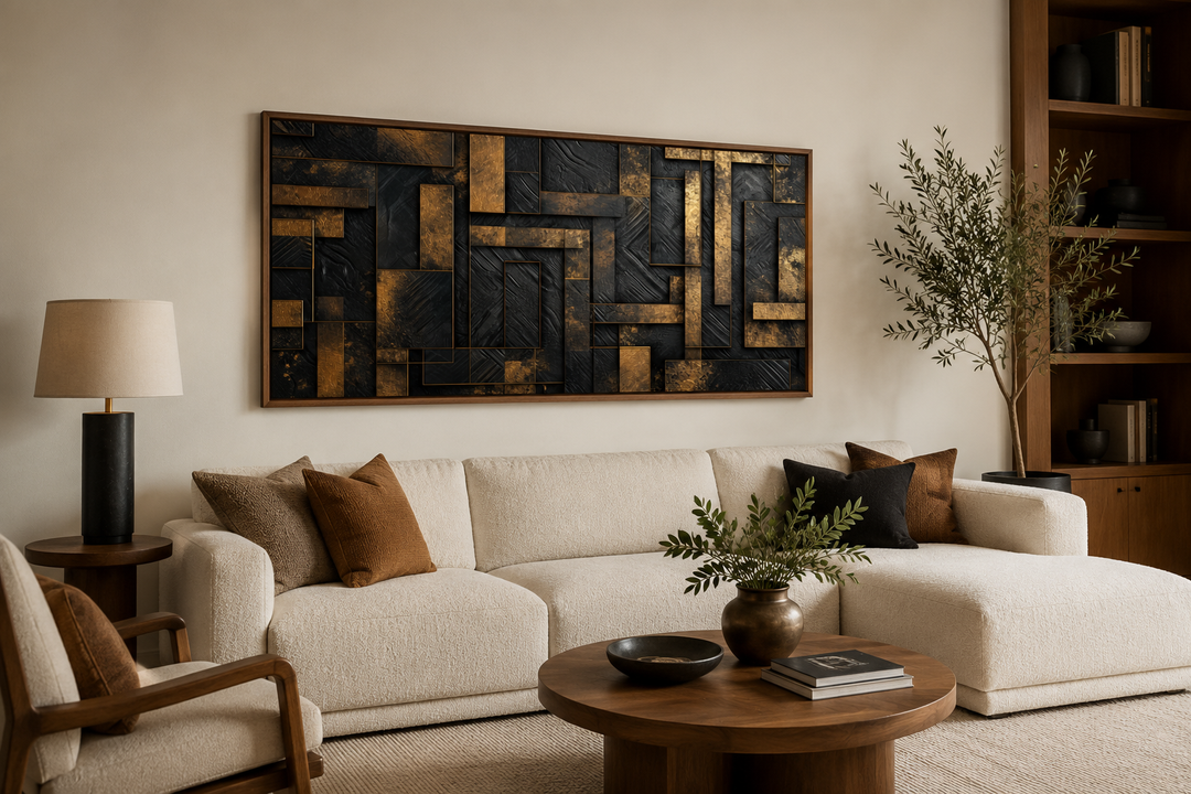 Black and gold abstract geometric framed canvas wall art mounted above a white sofa in a living room