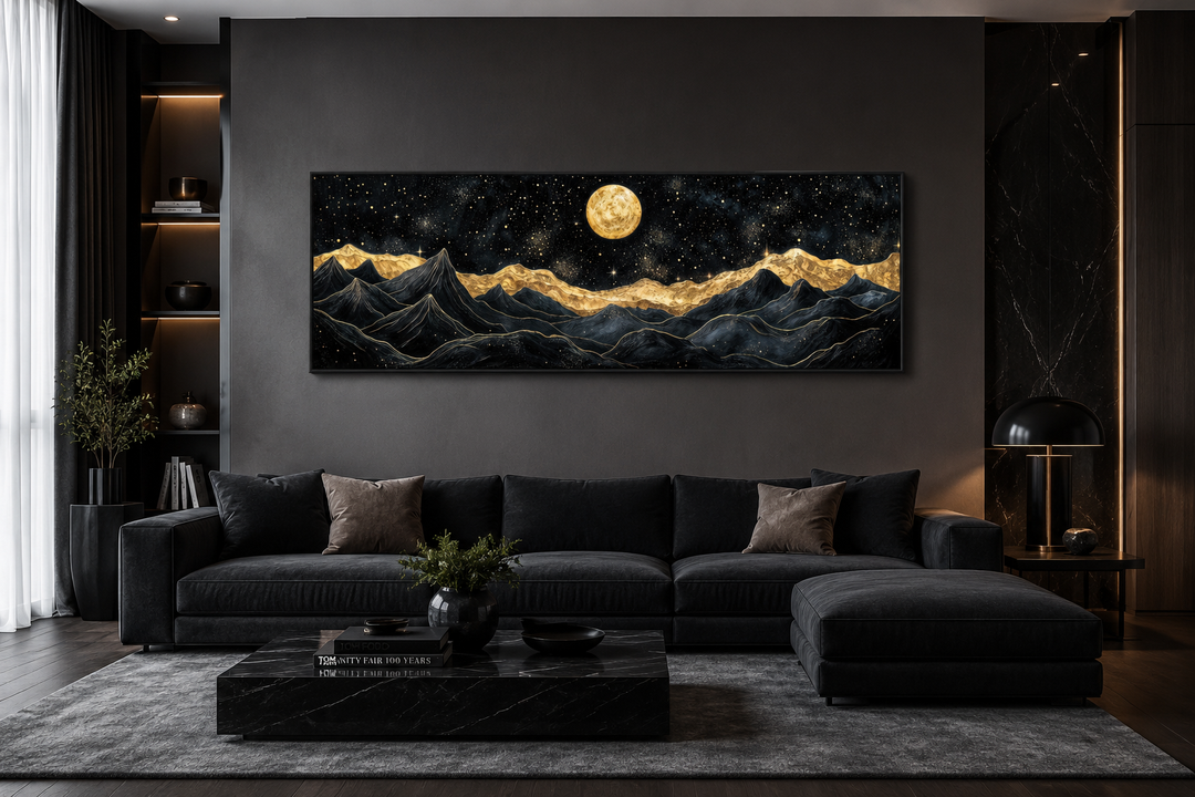 Wide canvas print of black mountains with gold peaks under a full moon in a modern living room.