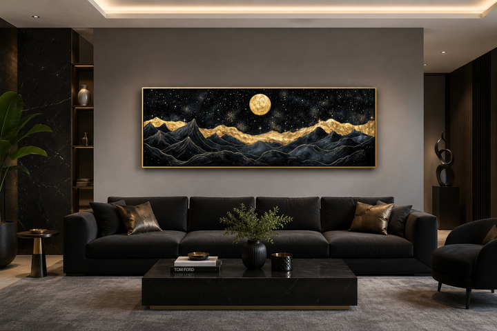 Black gold mountain wall art with a full moon over a dark sofa in a modern living room.