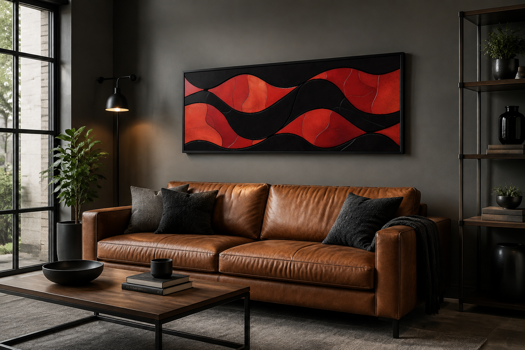 Horizontal framed canvas wall art with red and black abstract waves above a brown leather sofa.